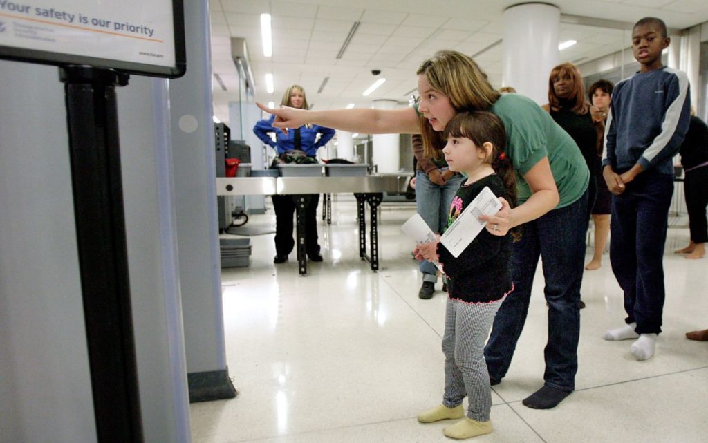 Disability news - woman and little girl are going through airport security.