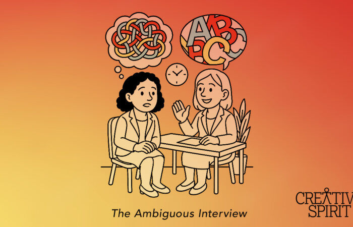 This image shows two individuals sitting at a table conducting a job interview. The interviewer is shown smiling with a text bubble above her filled with letters. The interviewee appears confused, with a tangled thought bubble above her. At the bottom of the image is a caption reading "The Ambiguous Interview". The image reflects the challenges frequently faced by neurodiverse job seekers, and represents the original article "The Interview Process Desperately Needs an Overhaul to Include Neurodiverse Employees. Here’s How It Can Happen." by Creative Spirit Communications Manager, Menachem Rephun.